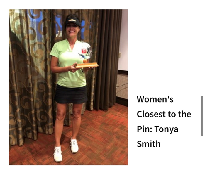 Female holding an award for closest to the pin